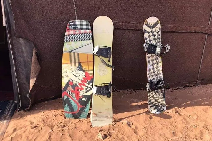 Three sandboards leaning against the side of a desert tent